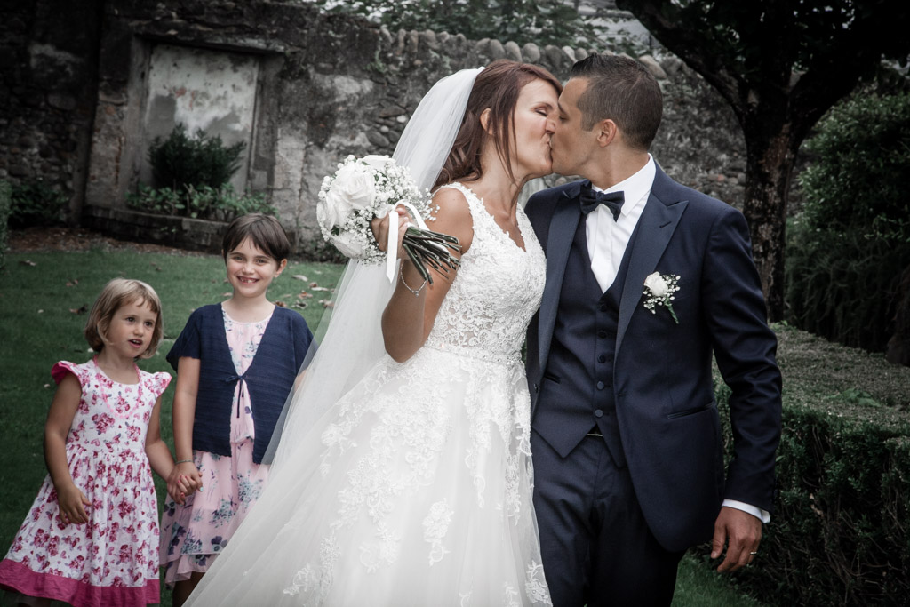 bacio degli sposi con bambini che guardano